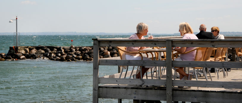 Gæster nyder udsigten over Nivå Havn fra Restaurant Trekostens terrasse